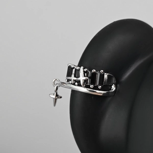 Gothic punk silver cross ring with black zircons on a professional jewelry display