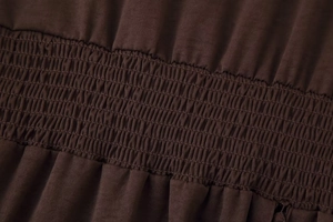 Detaillierte Makroansicht des elastischen Taillendesigns an diesem braunen Kleid
