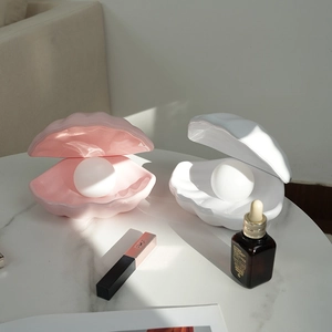 Detailed view of pink and white shell night lights with round bulbs on marble surface