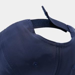 Dettaglio retro del cappellino blu navy con chiusura a strappo e tessuto con trama saia