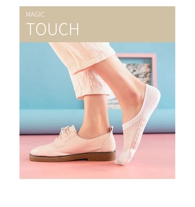 Detailed lace pattern of white cotton no-show socks worn with stylish leather shoes
