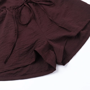 Detailed view of dark brown textured fabric with adjustable drawstring on the waist