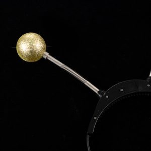 Detail of gold glitter balls with metal springs on a glowing Halloween headband
