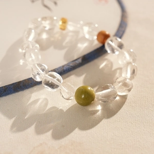 Détail macro de perles de cristal blanc et bois de santal vert sur surface en soie