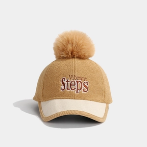 Close-up of khaki wool baseball cap with Vibrant Steps text and a yellow pompom