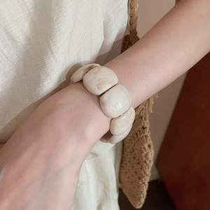 Close-up of geometric acrylic beaded bracelet with marble texture on wrist