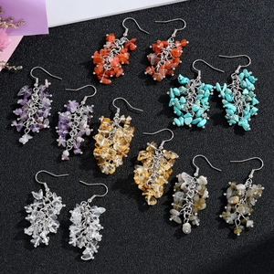 Macro detail of six pairs of handmade natural crystal chip tassel earrings set