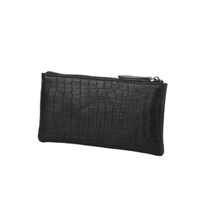 Detailed view of black crocodile pattern leather texture on a slim minimalist clutch bag