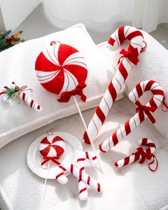 Macro detail of red and white striped fabric candy canes on white plush surface