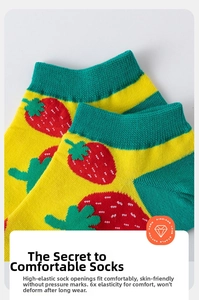 Close-up of strawberry knit patterns on yellow cotton socks showing detailed fabric texture