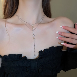 Close-up of double-layered silver star necklace with rhinestones on model's neckline