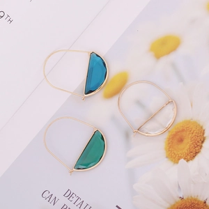Detail of geometric semi-circle glass earrings in blue, green, and clear finishes