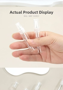 Close-up of portable clear glass perfume spray bottles with transparent plastic caps