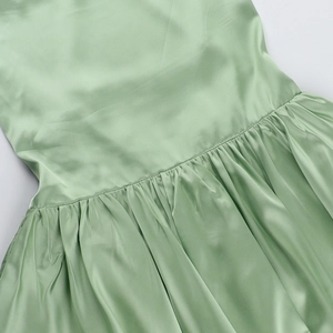 Detail of mint green satin summer dress featuring gathered waist and ruched stitching