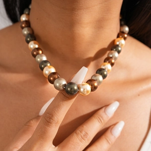 Gros plan d'un collier de perles bohème multicolore avec des perles dorées et argentées