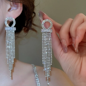 Close-up of elegant long tassel earrings with sparkling cubic zirconia on a model