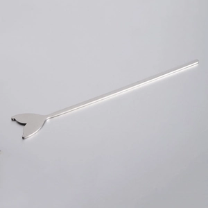 Close-up of a silver stainless steel mermaid tail metal stir stick with mirror finish
