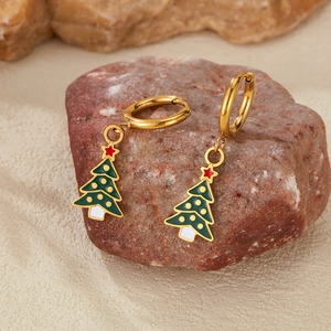 Detail of Christmas tree earrings with green enamel on a natural stone background