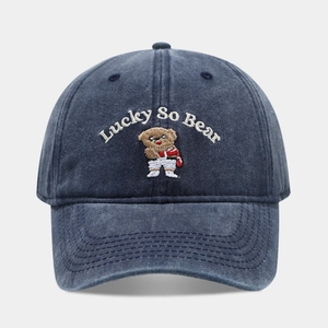Detailed close-up of the Lucky So Bear vintage embroidery on a navy washed cotton cap