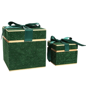 Deep green luxury gift boxes with satin bows and elegant gold trim on white background