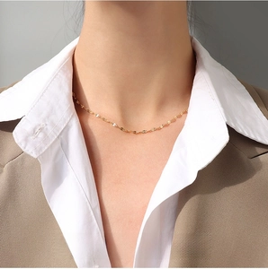 Detail of 2.3mm gold sequin chain necklace shown on model for elegant urban styling