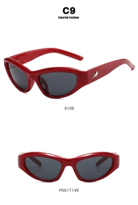 Detail view of red cat-eye sunglasses featuring a silver star emblem and dark lenses