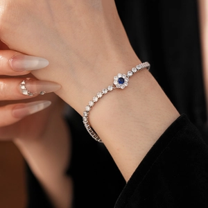 Macro detail of silver flower bracelet with blue zircon center and sparkling crystals
