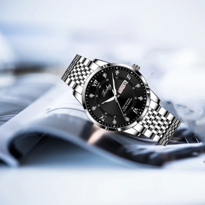 Detailed close-up of a silver men's watch featuring a black dial and calendar display