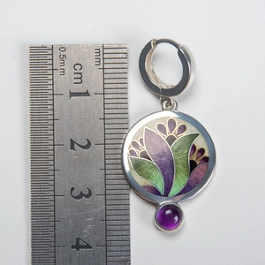 Detailed scale view of vintage silver floral earrings with purple and green enamel inlay