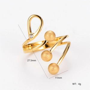 Gold spiral ring with matte beads and sparkling cubic zirconia crystal on white background