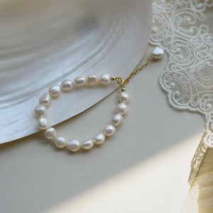 French Baroque freshwater pearl bracelet with gold adjustable clasp on white shell background