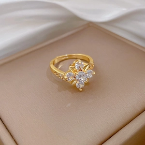 Macro shot of gold floral ring with cubic zirconia stones on luxury leather base