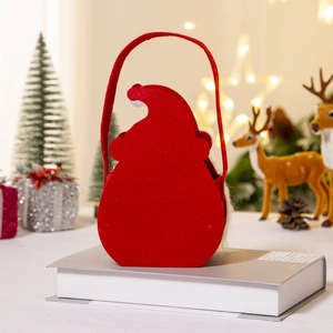 Close-up of red felt Christmas gift bag featuring Santa silhouette in a cozy festive setting