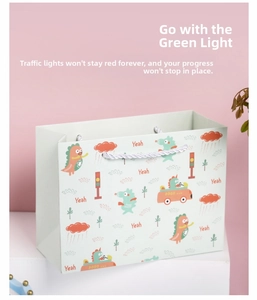 Detail der Cartoon Dinosaurier Geschenktüte mit Yeah Text und weißen Griffen