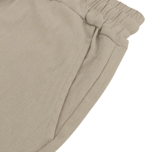 Detailed macro view of the elastic waistband and pocket on breathable linen shorts