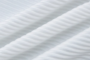 Detail of white textured fabric with elegant pleats and ruched finish on the dress