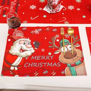Festive red Christmas placemat with Santa Claus and reindeer on a white tabletop