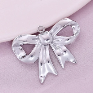 Detailed macro shot of a silver bow pendant in polished 304 stainless steel