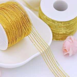 Close-up of 18K gold plated copper jewelry chains on white spools for DIY crafting