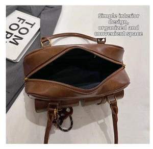 Top view of brown leather bag interior with gold zipper and spacious black lining