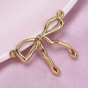 Macro shot of gold bow pendant in 304 stainless steel with side connector loops