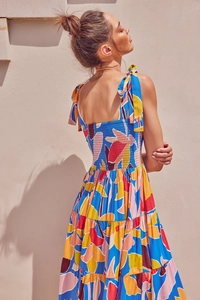 Detail of vibrant floral print dress with smocked back and tiered skirt construction