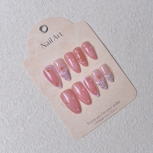 Macro detail of almond press-on nails featuring 3D flowers, pearls, and zebra patterns