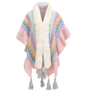 Detail of pink knitted shawl featuring colorful wave patterns, white faux fur collar and tassels