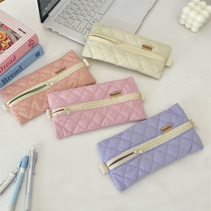 Close-up of quilted pencil cases in pastel colors with high-quality zipper detail