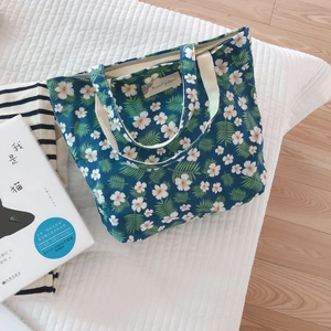 Close-up of floral navy canvas tote bag with zipper and cream webbing handles