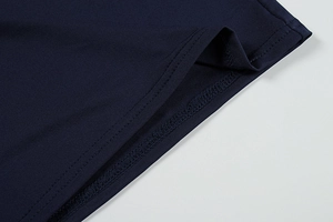Detail of precise double-needle stitching on navy blue knit dress hemline fabric