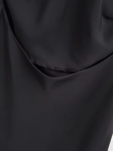 Close-up of high-quality stitching and satin fabric texture on black camisole dress