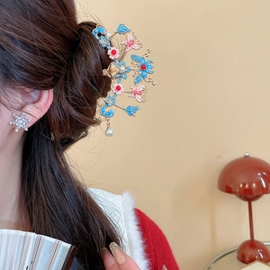 Détail d'épingle à cheveux fleur papillon vintage avec pompons en perles sur cheveux