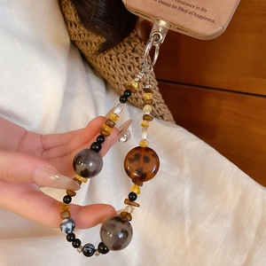 Detail of vintage acrylic beaded phone chain with amber beads and metal lobster clasp